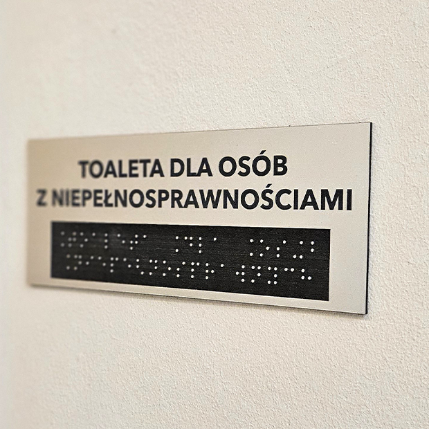Obraz przedstawia tabliczkę napisaną alfabetem braille'a