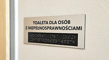 Obraz przedstawia tabliczkę napisaną alfabetem braille'a