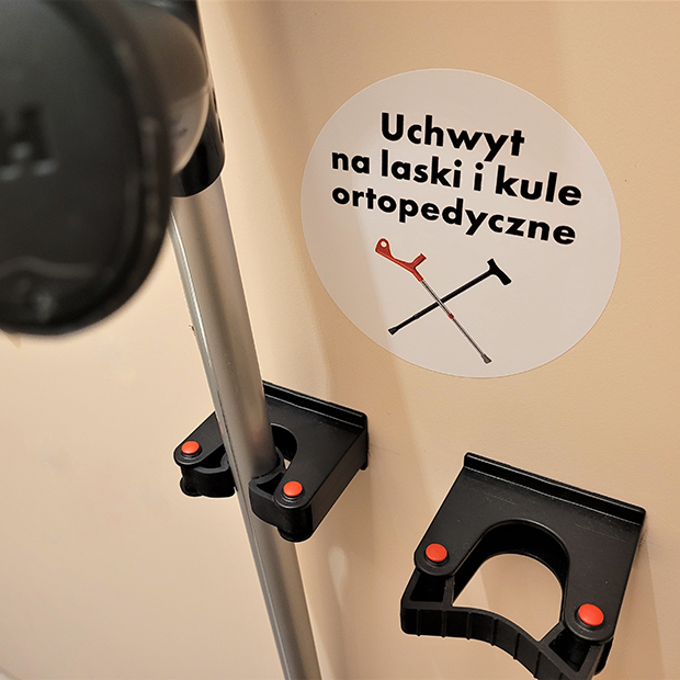 Obraz przedstawia uchwyty na laski i kule ortopedyczne w toalecie