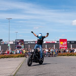 motocyklista jadący motorem na stojąco nie trzymając się rękoma